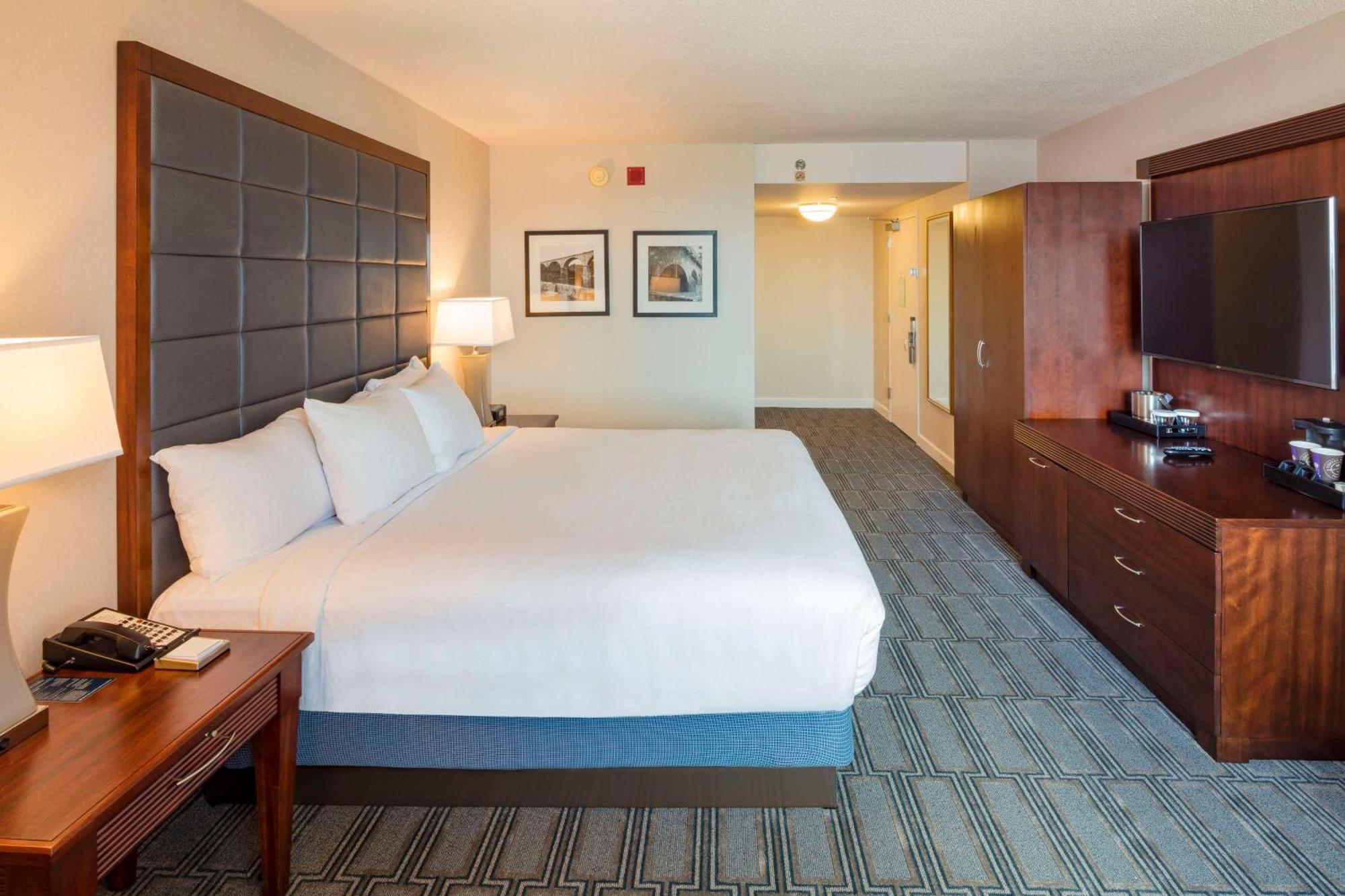 Deluxe Zimmer mit Kingsize-Bett und Blick auf die Skyline