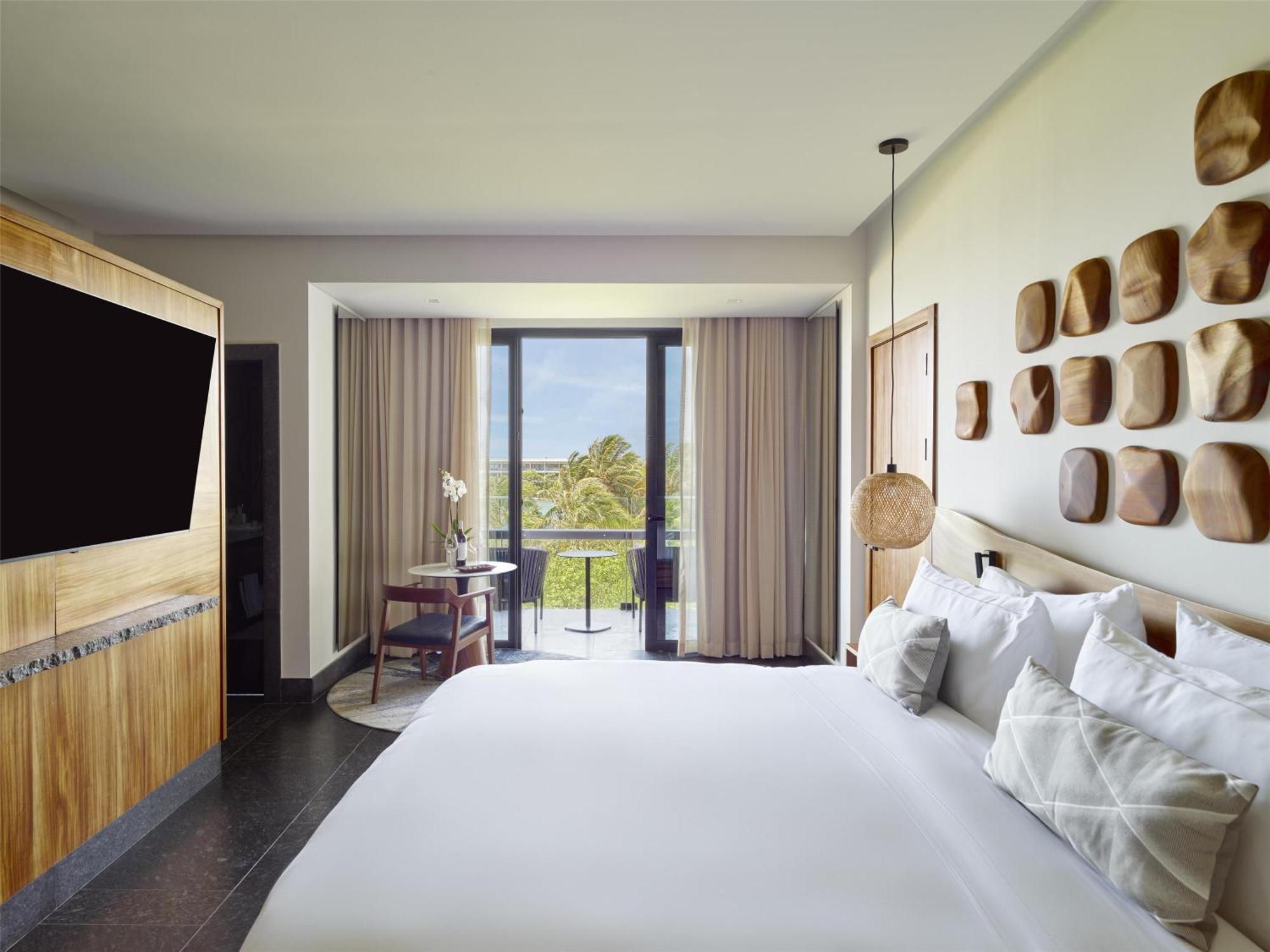 Suite mit Kingsize-Bett und Aussicht auf die tropische Landschaft