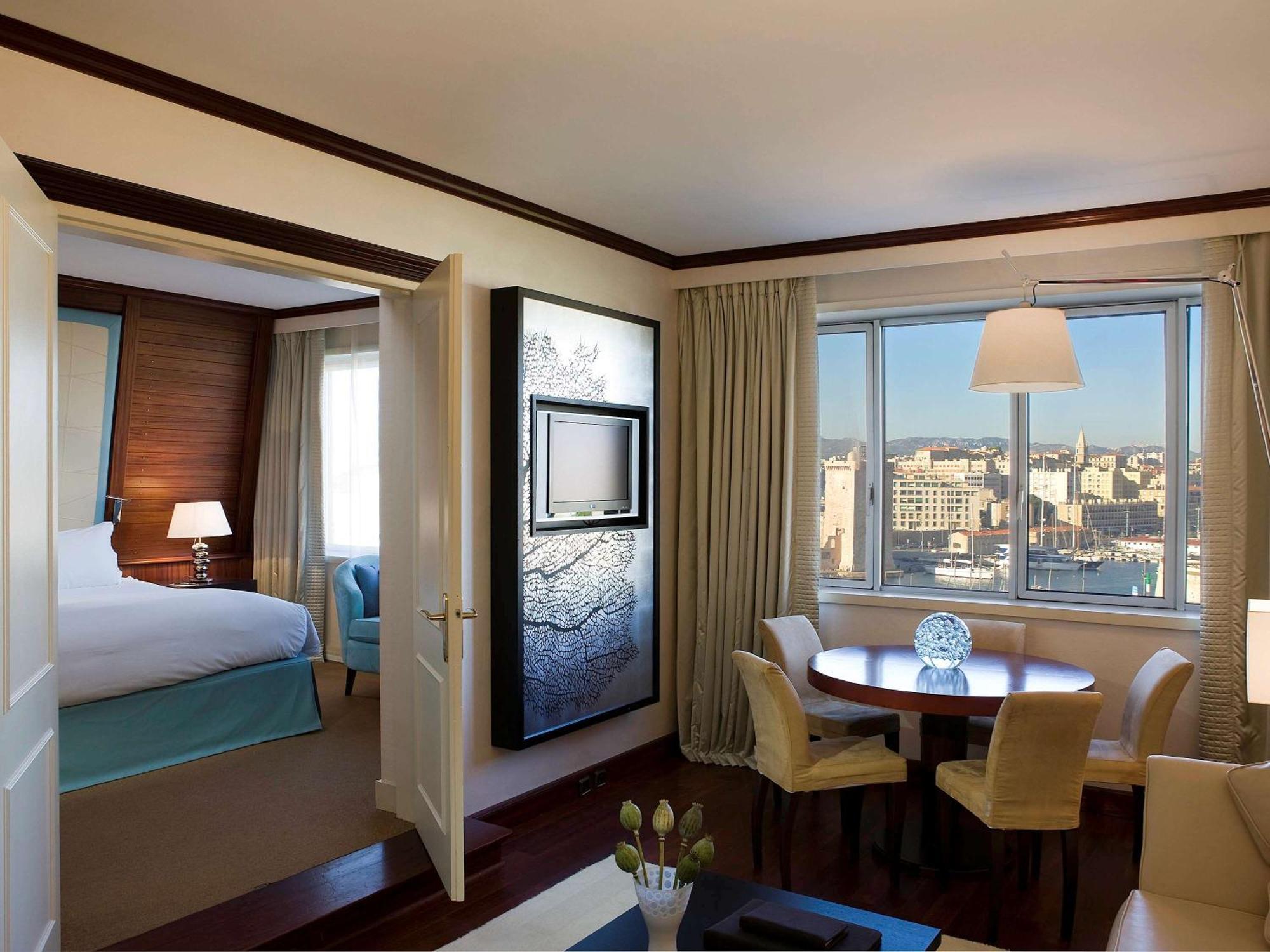 Suite Opera mit Kingsize-Bett und Blick auf den Alten Hafen und Loungebereich – Dachgeschoss und Zugang zum Spa/Fitnessstudio
